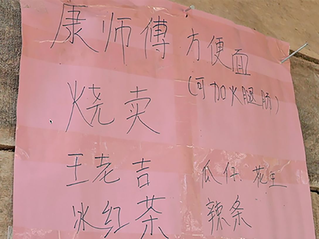 Another sign written in Chinese states different snacks and drinks for sale.